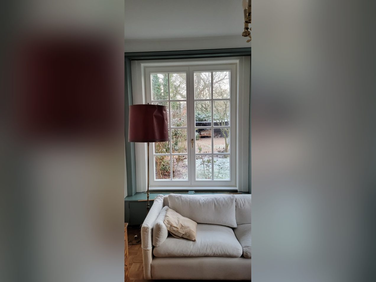 Weiße zweiflügelige Holzfenster mit Sprossen in einem Altbau-Wohnzimmer