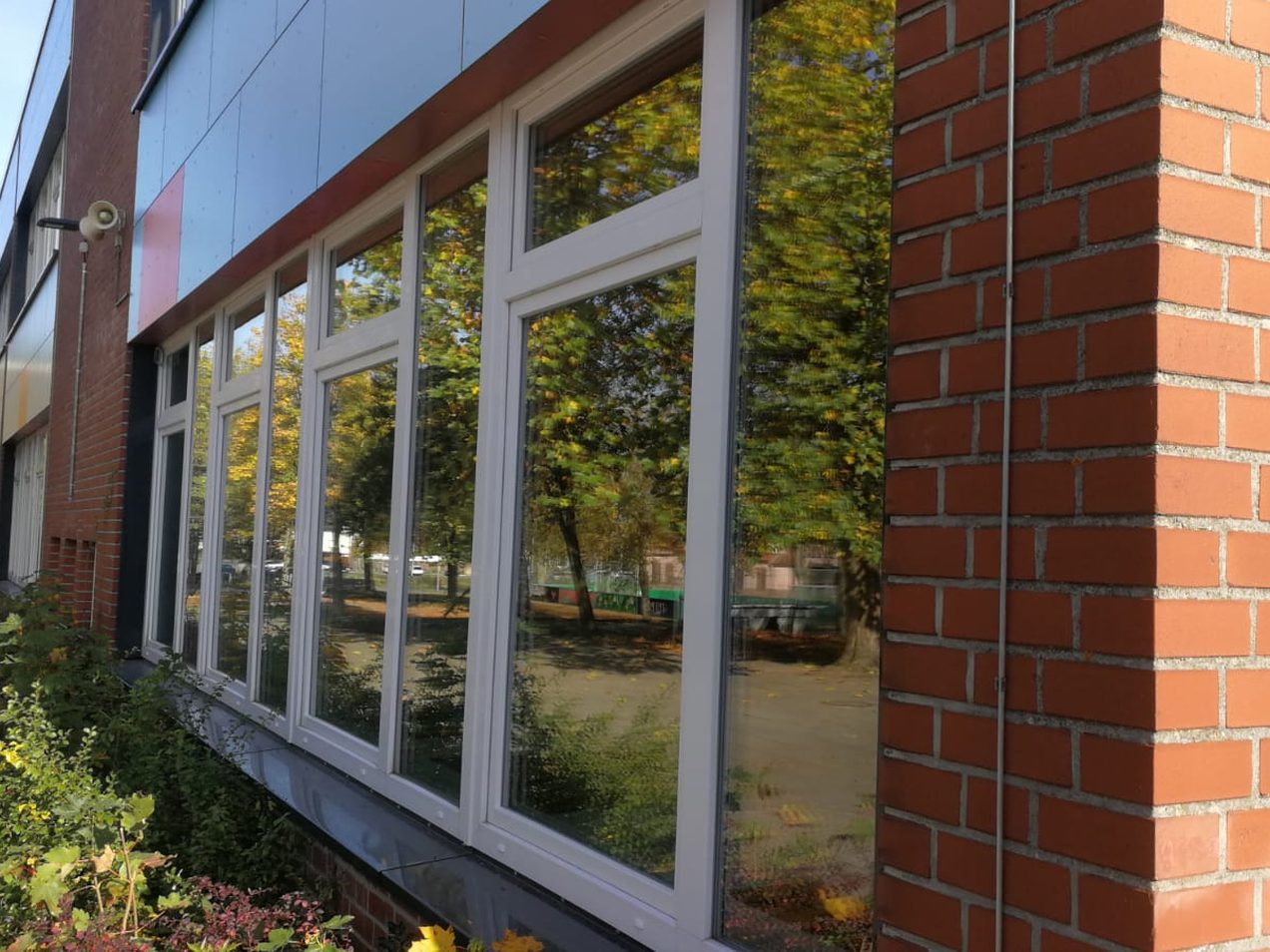 Fensterband aus weißen Kunststofffenstern an einer Schule mit Klinkerfassade