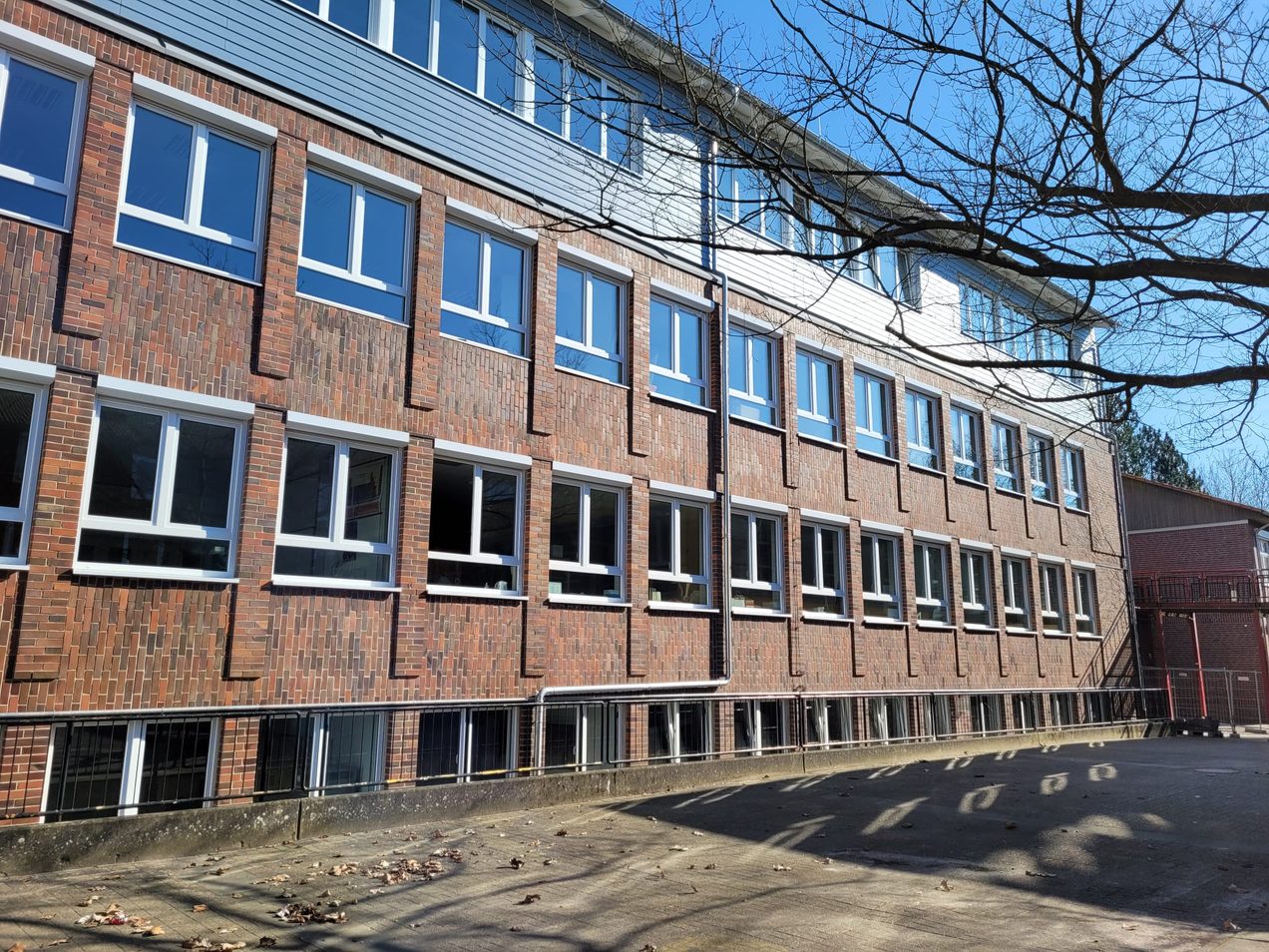 Neue weiße Kunststofffenster in der Klinkerfassade eines Schulgebäudes