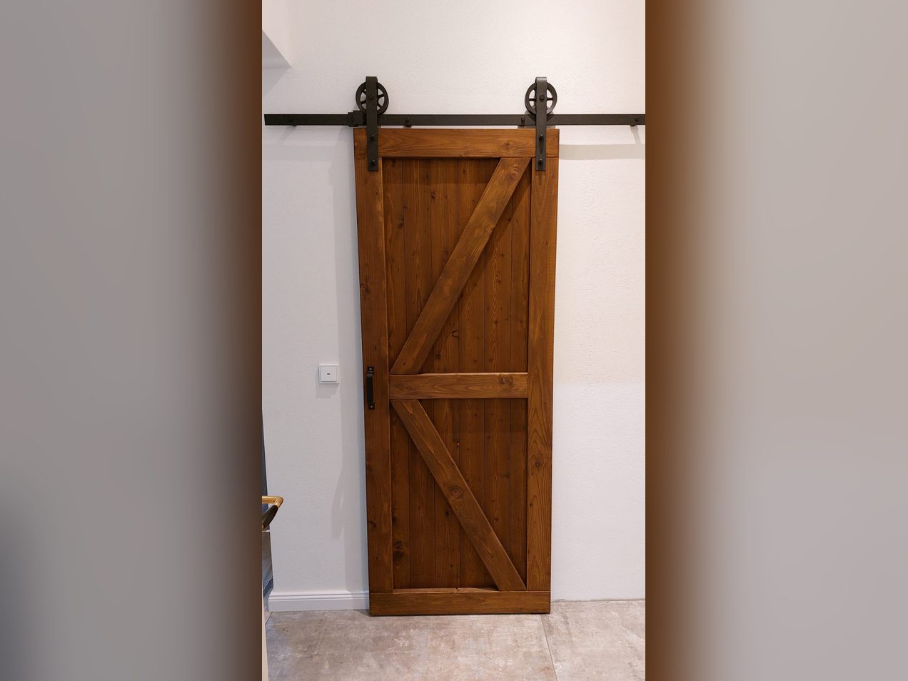 Schiebetür aus Holz im Scheunentor-Stil mit schwarzer Laufschiene
