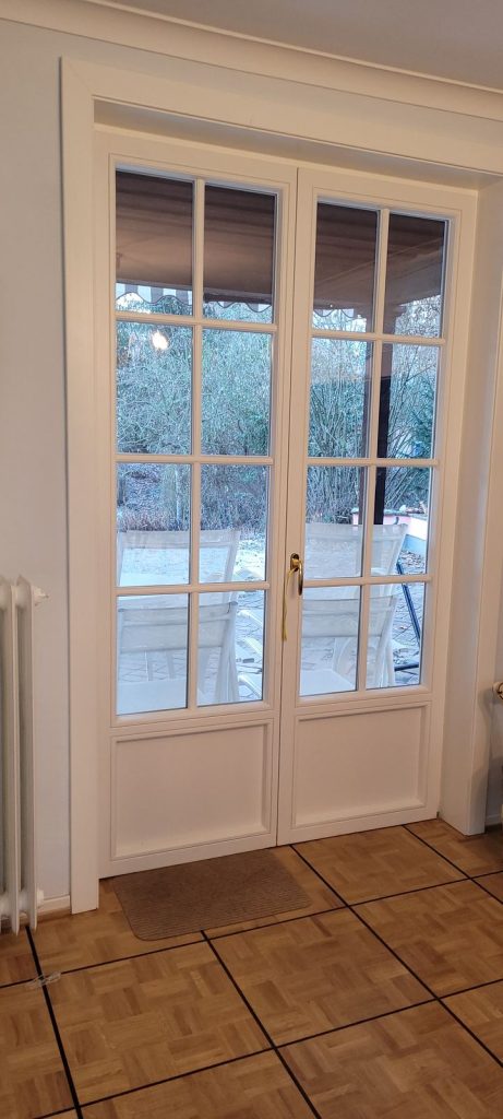 Zweiflügelige Fenstertür mit Sprossen und Blick auf die Terrasse